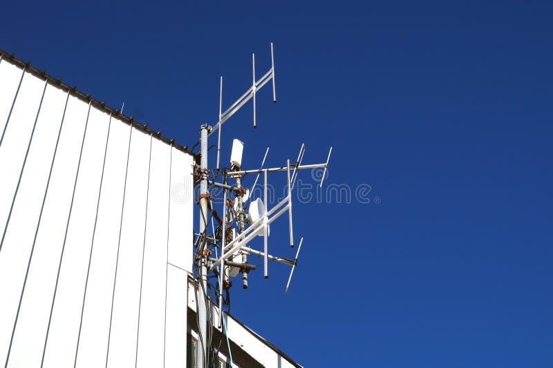 Telekommunikationen står högt med TVantenner och den satellit- maträtten på klar blå himmel royaltyfria foton Telekommunikationen står högt med TVantenner och den satellit- maträtten på klar blå himmel royaltyfria foton