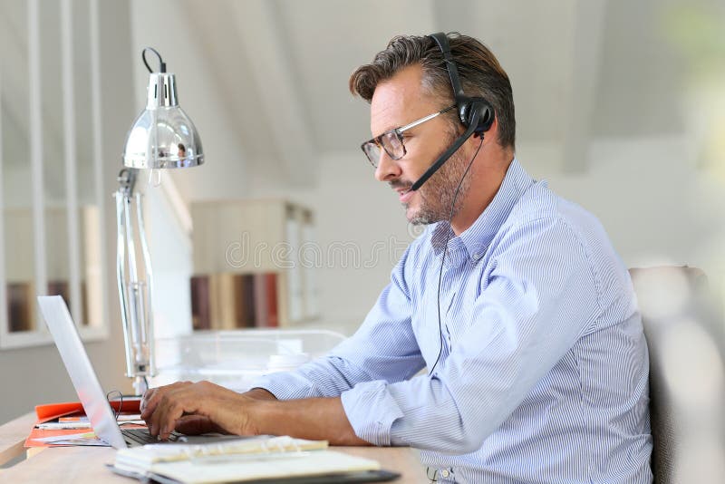 Telelavoro bello dell'uomo d'affari fotografie stock libere da diritti Telelavoro bello dell'uomo d'affari fotografie stock libere da diritti