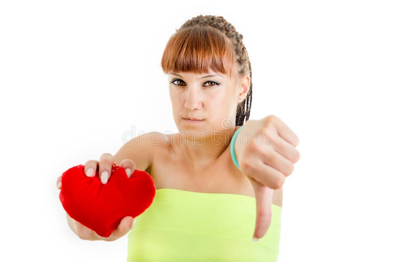 Teleurgestelde jonge vrouw die droevig hart houden die duim neer tonen stock foto Teleurgestelde jonge vrouw die droevig hart houden die duim neer tonen stock foto