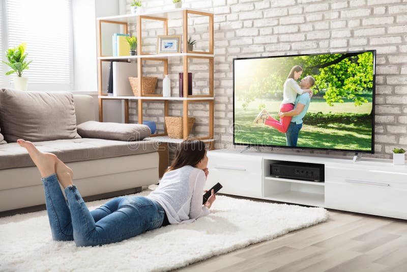 Foto de Dois Amigos Sorridentes No Sofá Assistindo Tv Juntos No Escuro e  mais fotos de stock de Assistir TV - iStock