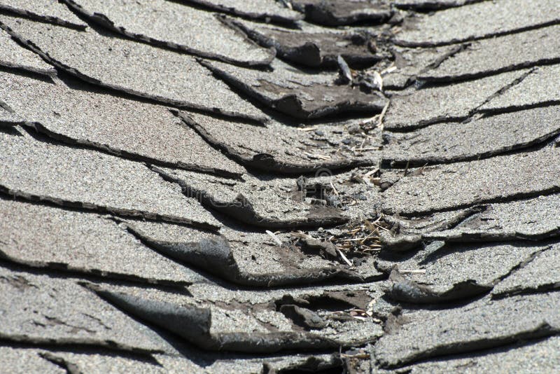 Telhas más e ondulando velhas do telhado em uma casa ou em uma casa