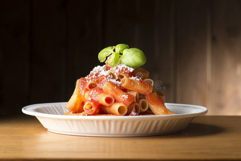 Teller mit Makkaroni und Tomatensauce auf dem Holztisch lizenzfreies stockbild Teller mit Makkaroni und Tomatensauce auf dem Holztisch lizenzfreies stockbild