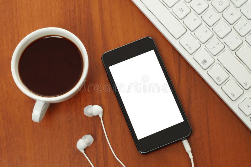 Teléfono elegante con la taza de los auriculares, del teclado y de café fotografía de archivo libre de regalías Teléfono elegante con la taza de los auriculares, del teclado y de café fotografía de archivo libre de regalías
