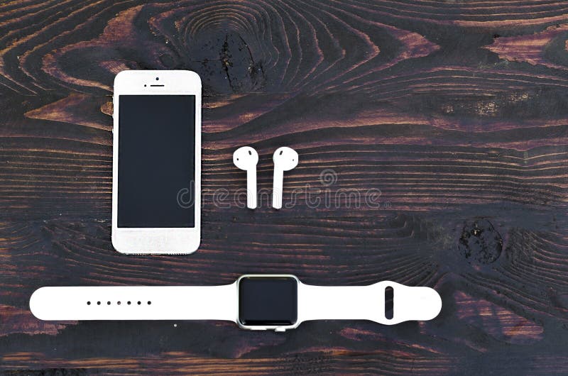 Teléfono inteligente blanco iPhone 5S+, reloj inteligente Apple deporte con una banda y auriculares inalámbricos Airpods en segu ilustración del vector Teléfono inteligente blanco iPhone 5S+, reloj inteligente Apple deporte con una banda y auriculares inalámbricos Airpods en segu ilustración del vector