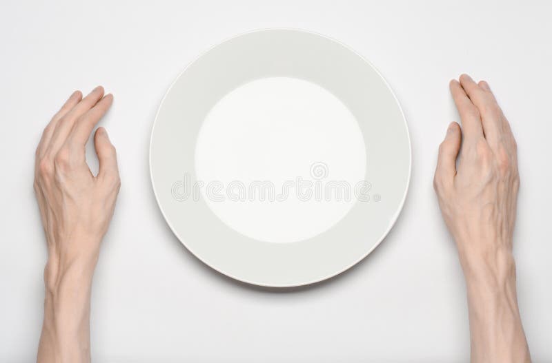 Tema del restaurante y de la comida: el gesto humano de la demostración de la mano en una placa blanca vacía en un fondo blanco e foto de archivo libre de regalías Tema del restaurante y de la comida: el gesto humano de la demostración de la mano en una placa blanca vacía en un fondo blanco e foto de archivo libre de regalías