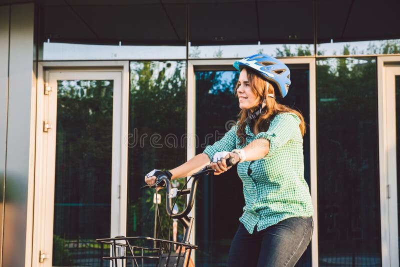 Tema som arbetar p? cykeln En ung Caucasian kvinna ankom p? den milj?v?nliga transportcykeln till kontoret Flicka i a arkivfoton Tema som arbetar p? cykeln En ung Caucasian kvinna ankom p? den milj?v?nliga transportcykeln till kontoret Flicka i a arkivfoton