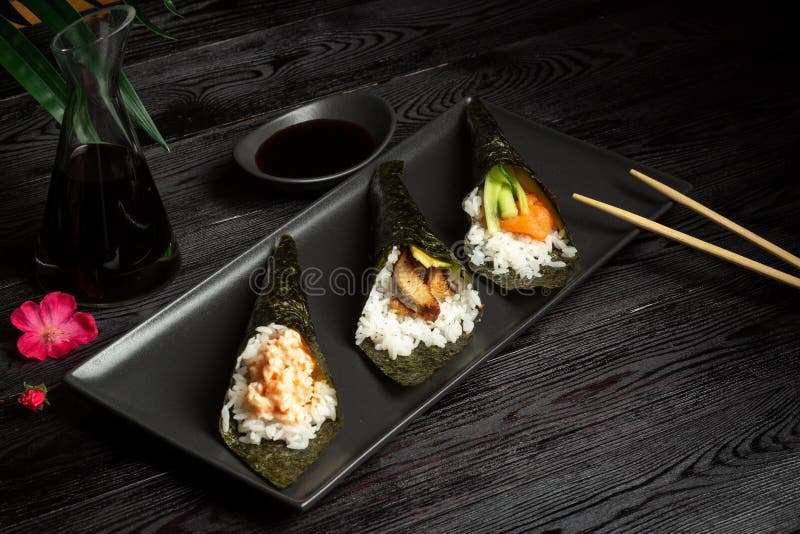 Temaki-Mischung mit Lachsen, Aal und Garnele auf einem dunklen h?lzernen Hintergrund stockbilder Temaki-Mischung mit Lachsen, Aal und Garnele auf einem dunklen h?lzernen Hintergrund stockbilder