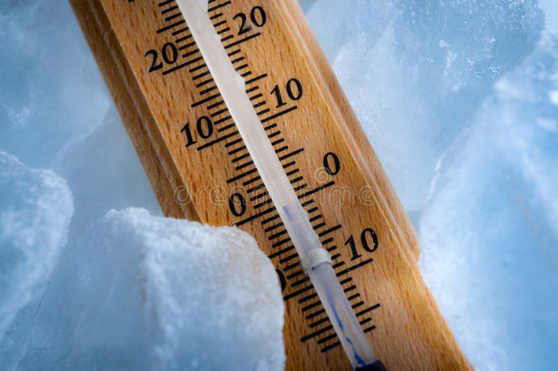 Temperaturas de congelação e conceito do tempo frio com fim acima em um termômetro do vintage cercado pelo sub azul da exibição d imagens de stock Temperaturas de congelação e conceito do tempo frio com fim acima em um termômetro do vintage cercado pelo sub azul da exibição d imagens de stock
