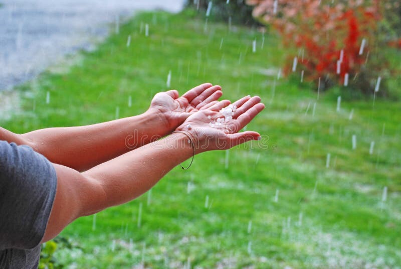 Girl holding hands out to catch hail. Girl holding hands out to catch hail.