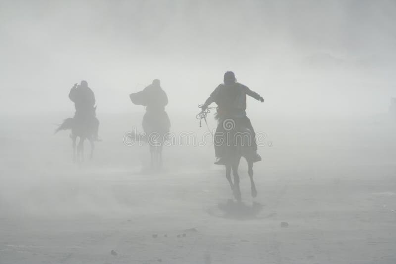 Tempestade de areia, cavaleiros a cavalo no Monte Bromo imagens de stock