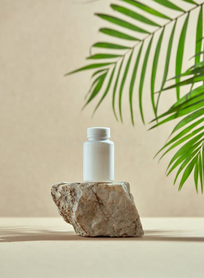 Template white plastic jar on stone pedestal with palm leaves. Dietary supplements, vitamins presentation. Mockup. Podium for cosmetics products advertising. High quality photo