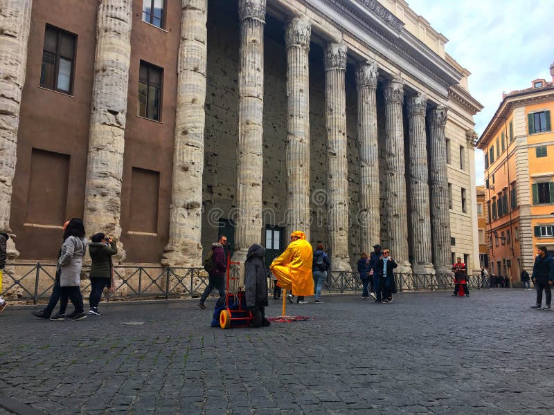 Temple of Hadrian, Rome, Italy - December 26, 2017: A street performer in the Piazza di Pietra.