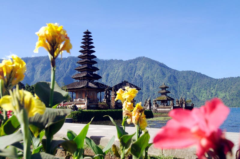 Beautiful temple on lake in extinct volcano crater with yellow flowers in the foreground. Beautiful temple on lake in extinct volcano crater with yellow flowers in the foreground