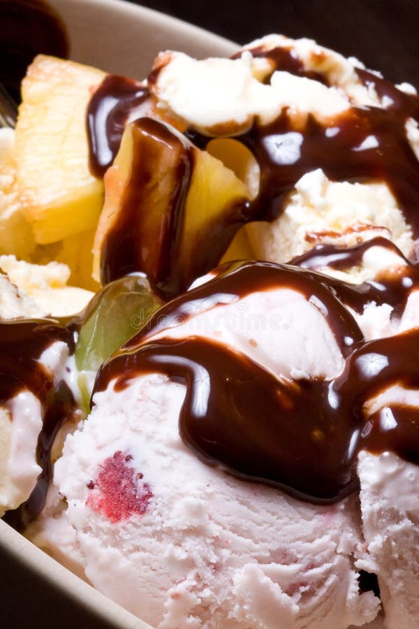 Ice cream covered in chocolate shot close up dark background. Ice cream covered in chocolate shot close up dark background