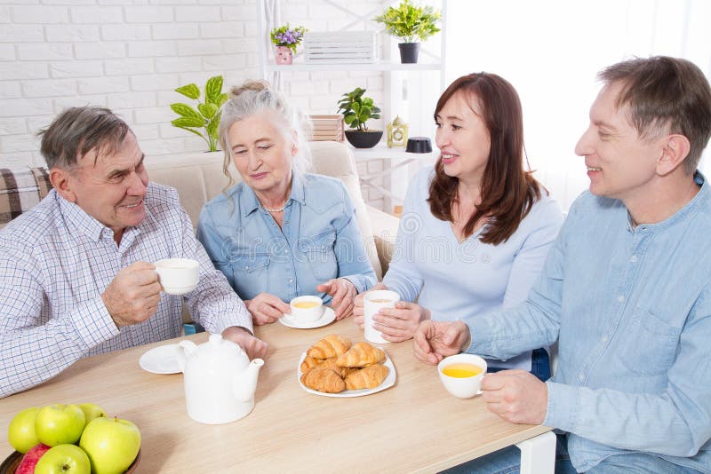 Tempo felice del tè della famiglia alla casa di cura per gli anziani I genitori con i bambini si divertono la comunicazione e lo fotografia stock Tempo felice del tè della famiglia alla casa di cura per gli anziani I genitori con i bambini si divertono la comunicazione e lo fotografia stock