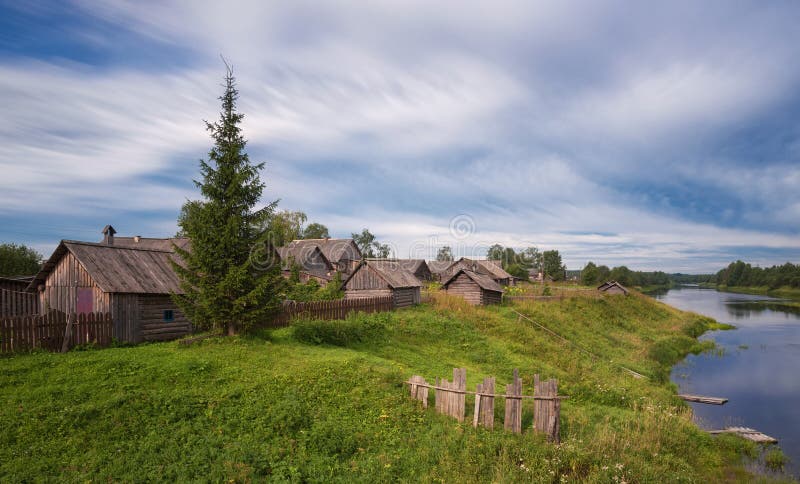 Tempo nuvoloso di estate abbellisca con River Valley e la casa tipica del villaggio nella campagna La vecchia fattoria immagini stock libere da diritti Tempo nuvoloso di estate abbellisca con River Valley e la casa tipica del villaggio nella campagna La vecchia fattoria immagini stock libere da diritti