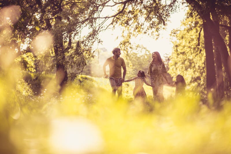 Temps de famille Parents heureux avec leurs petites filles en nature photos libres de droits Temps de famille Parents heureux avec leurs petites filles en nature photos libres de droits