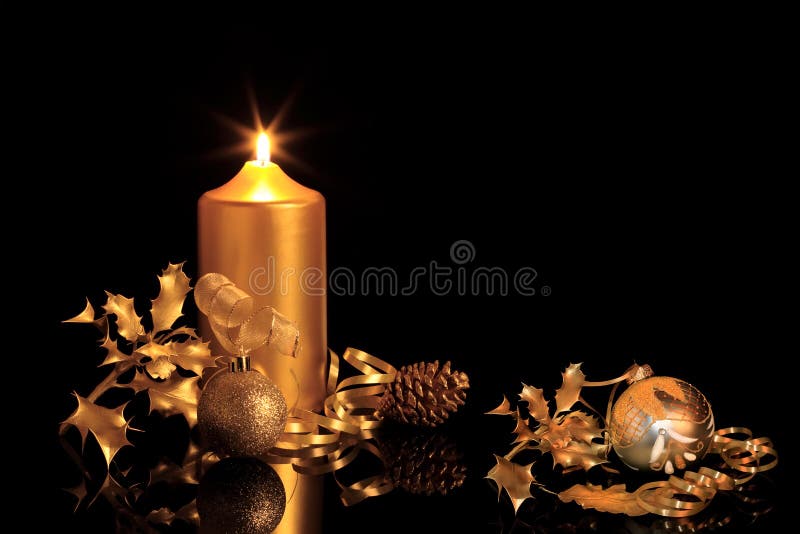 Golden christmas decorations in candlelight with baubles, ribbon, holly, oak leaves and pine cone, over black background with reflection. Golden christmas decorations in candlelight with baubles, ribbon, holly, oak leaves and pine cone, over black background with reflection.