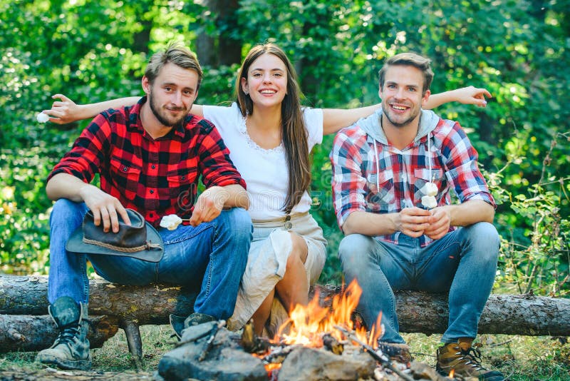 Picnic time. Friends camping concept. Tourists relaxing. Company friends enjoy relaxing together in forest. They are sitting around camp fire. Happy people sitting around campfire. Picnic time. Friends camping concept. Tourists relaxing. Company friends enjoy relaxing together in forest. They are sitting around camp fire. Happy people sitting around campfire