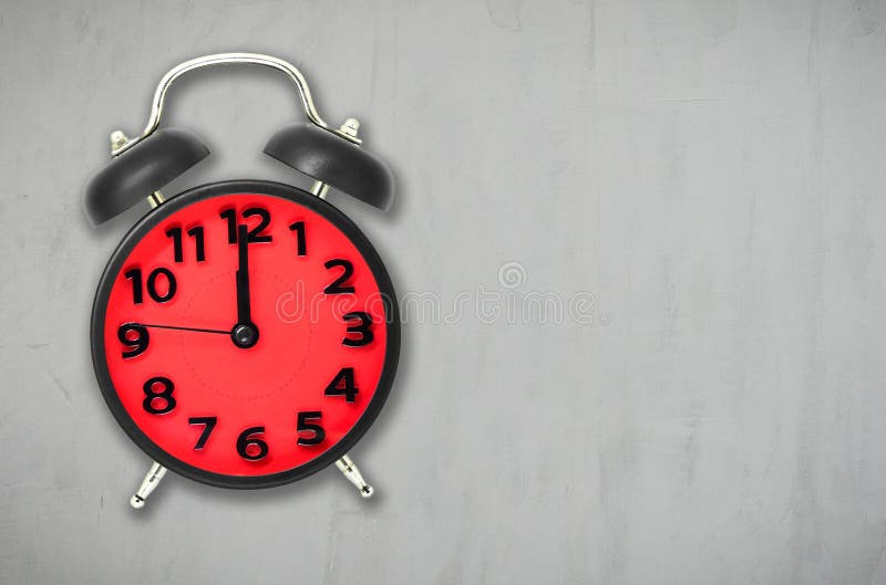 Temps rouge de déjeuner de réveil sur le fond gris de ciment photographie stock Temps rouge de déjeuner de réveil sur le fond gris de ciment photographie stock