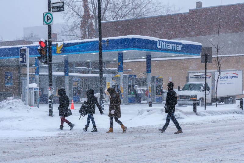 Montreal, CA - 2 February 2021: People walking on the street during heavy snowfall. Montreal, CA - 2 February 2021: People walking on the street during heavy snowfall