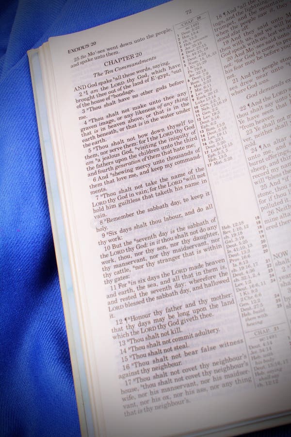 Shot of Bibles Ten Commandments from the King James Version of the Bible. Selective focus on the first few verses of Exodus 20. Blue cloth. Shot of Bibles Ten Commandments from the King James Version of the Bible. Selective focus on the first few verses of Exodus 20. Blue cloth.