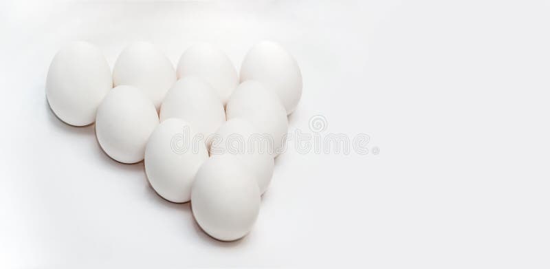 Ten white eggs on a white background in the form of a triangle. Healthy food. Healthy lifestyle. Protein and yolk in the shell. royalty free stock images Ten white eggs on a white background in the form of a triangle. Healthy food. Healthy lifestyle. Protein and yolk in the shell. royalty free stock images
