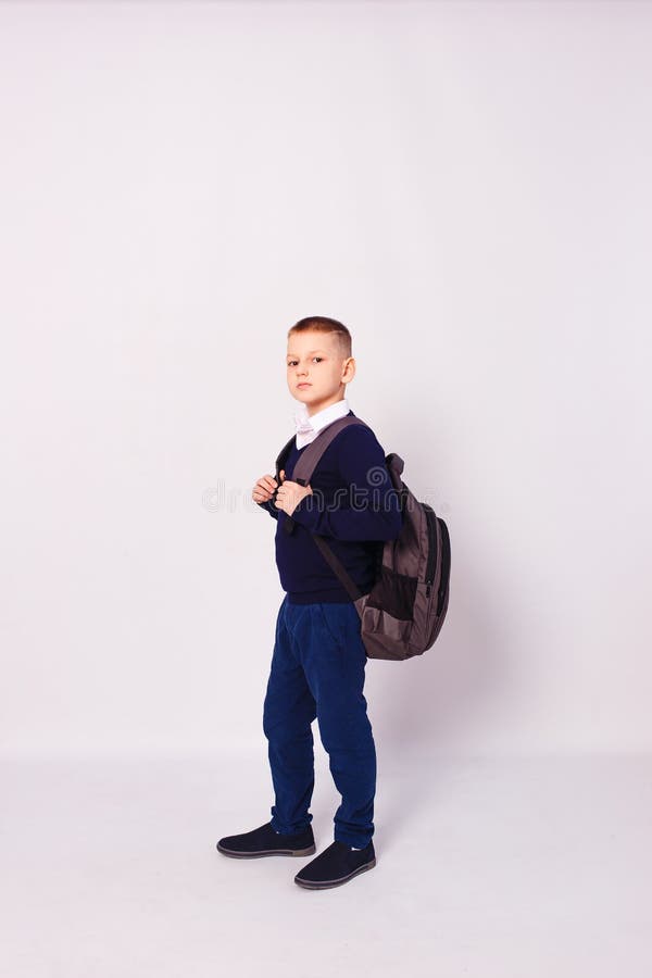 Tenyearold Boy in School Uniform with Backpack on His Back Stock