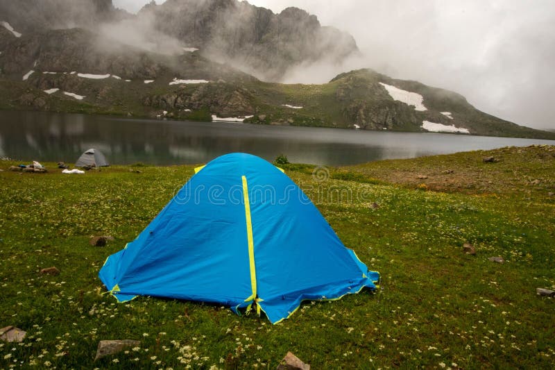Tenda sul lago verde d'erba sullo sfondo fotografia stock libera da diritti