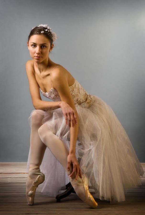 Tender ballet dancer sitting isolated