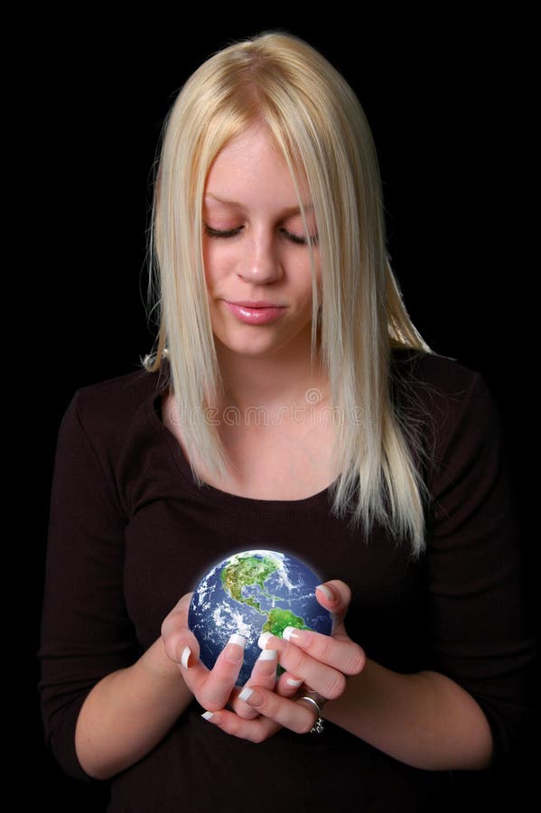 Woman lovingly holding the earth in her hands isolated over a black background. Woman lovingly holding the earth in her hands isolated over a black background.