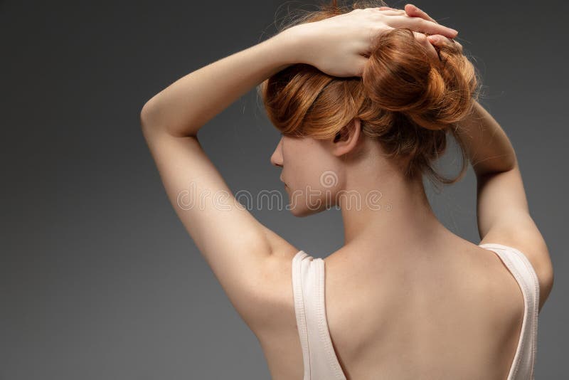 Tender. Fashion portrait of beautiful redhead woman isolated on grey studio background. Concept of beauty, skin care, fashion and style. Artwork, modern and trendy portrait. Attractive model.