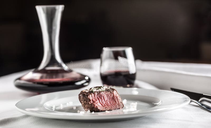 Tenderloin βόειου κρέατος μπριζόλα στο άσπρο πιάτο και κόκκινο κρασί στο μπαρ ή το υπόλοιπο