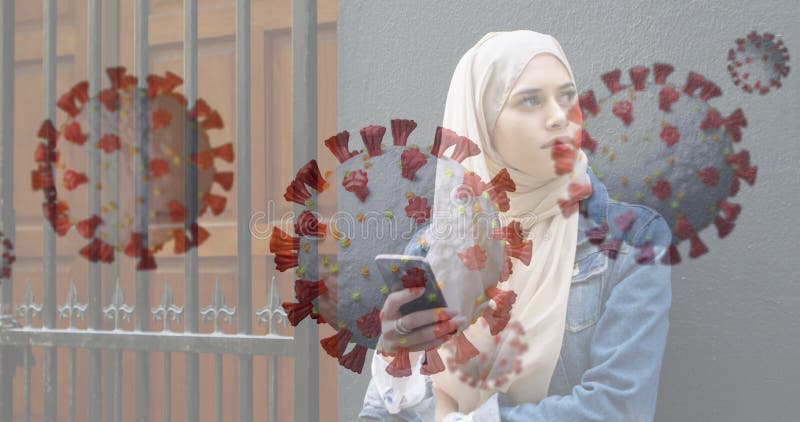 Tenere fuori casa una donna musulmana di smartphone con grafica coronavirus fotografia stock