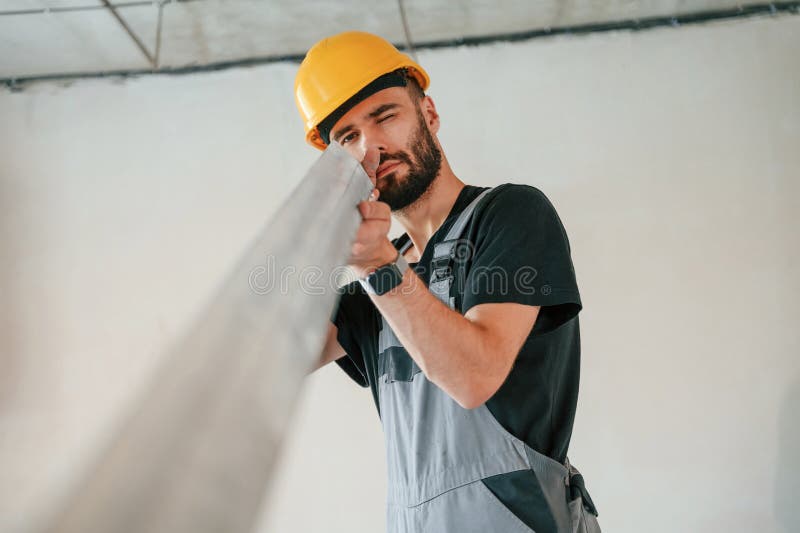 Tenere a mano materiale da costruzione. l'uomo sta riparando nell'appartamento fotografia stock