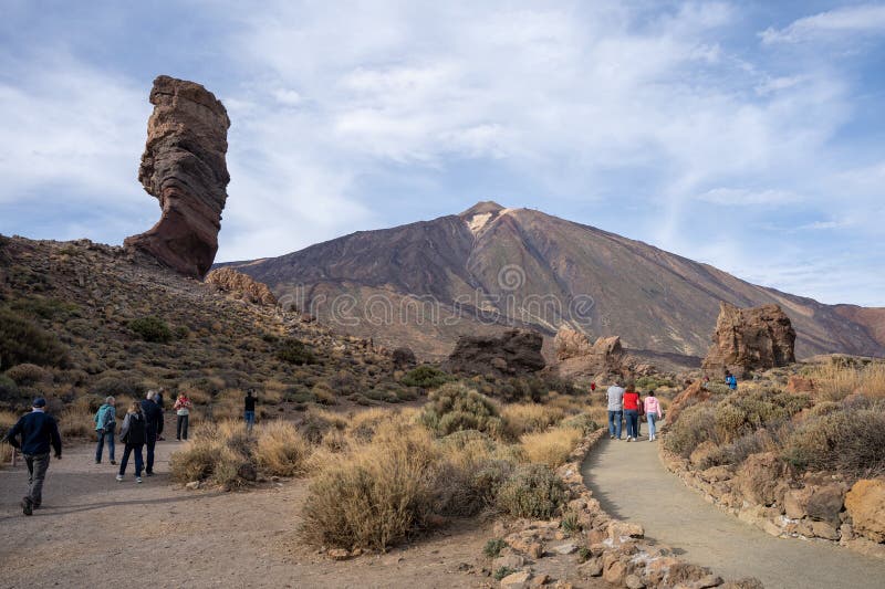 Tenerife, Spain - 04.12.2023: Tourists at Roque Cinchado with Mount Teide in background at Teide National Park, Canary Islands