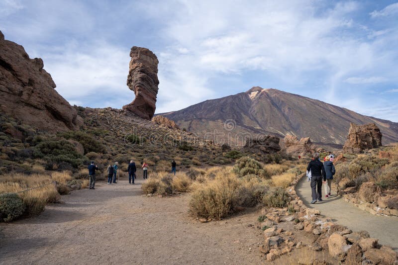 Tenerife, Spain - 04.12.2023: Tourists at Roque Cinchado with Mount Teide in background at Teide National Park, Canary Islands