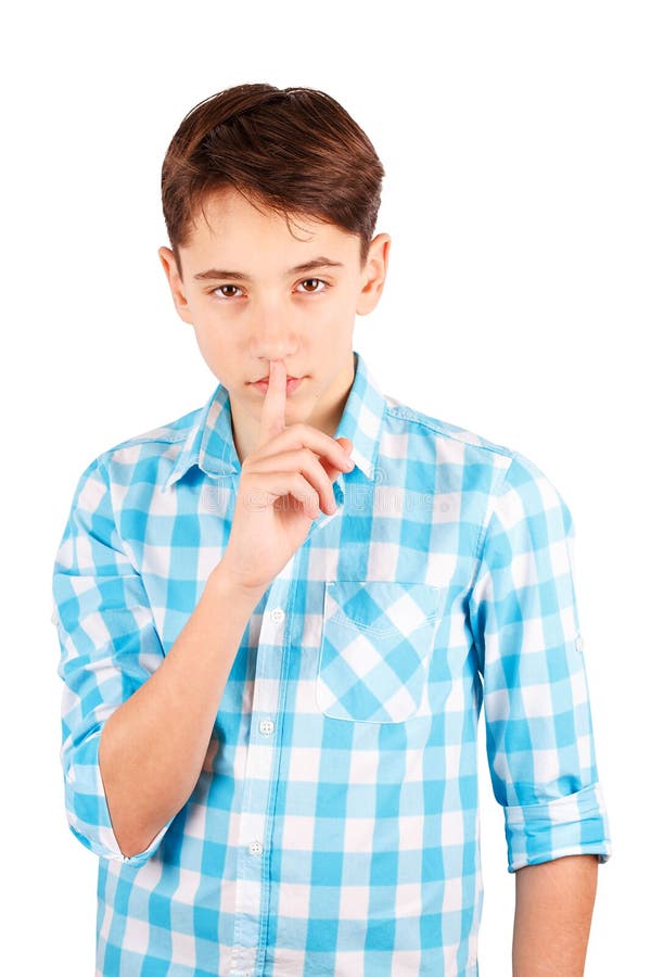 Tenga il mio segreto! Ragazzo teenager serio in dito della tenuta della camicia di plaid sulle labbra ed esaminare macchina fotog fotografie stock libere da diritti Tenga il mio segreto! Ragazzo teenager serio in dito della tenuta della camicia di plaid sulle labbra ed esaminare macchina fotog fotografie stock libere da diritti