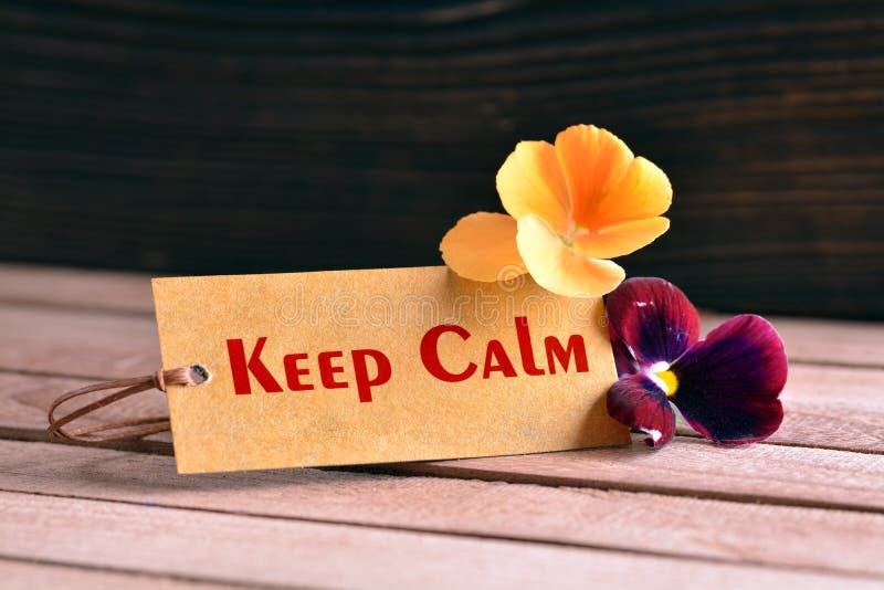 Tag banner keep calm and violet flower on wooden desk. Tag banner keep calm and violet flower on wooden desk