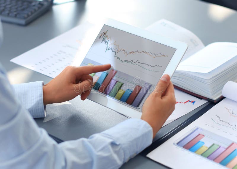 Business person analyzing financial statistics displayed on the tablet screen. Business person analyzing financial statistics displayed on the tablet screen