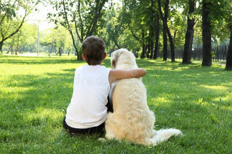 Tennager boy in the park with a dog