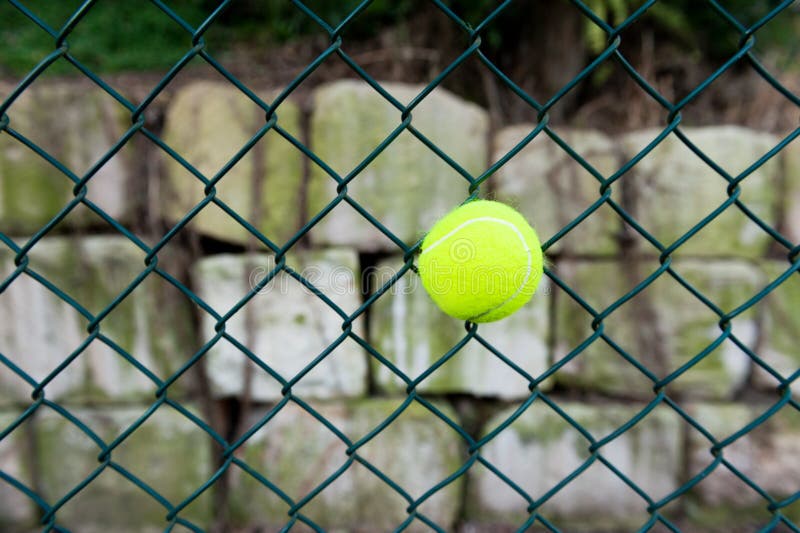 Tennis ball in fence stock photo. Image of horizontal 32407932