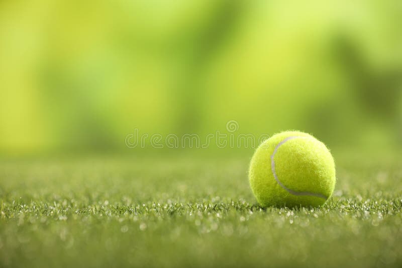 Tennis ball on green artificial grass, space for text royalty free stock photos