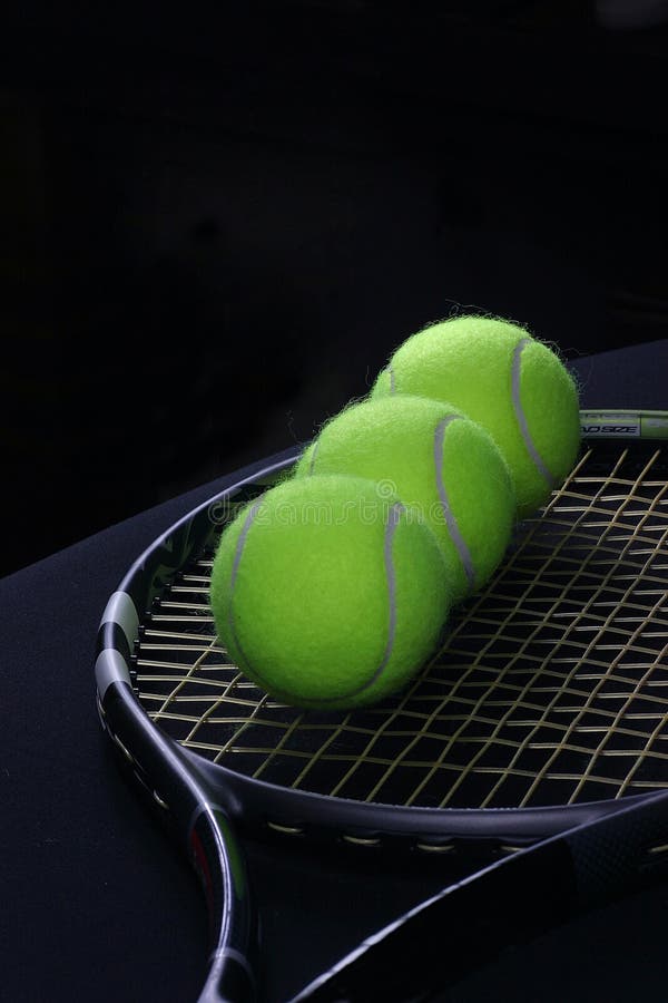 Tennis ball in the racket on the black background