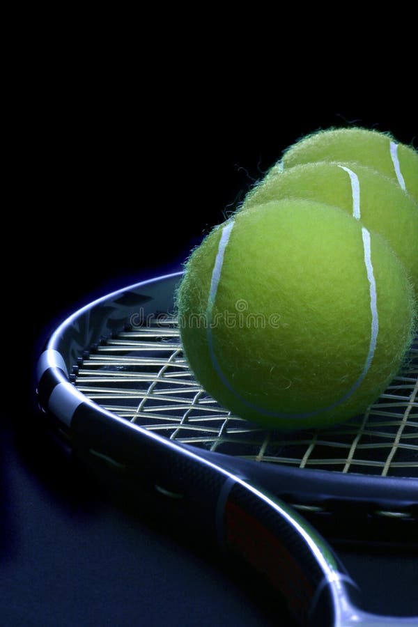 Tennis ball in the racket on the black background