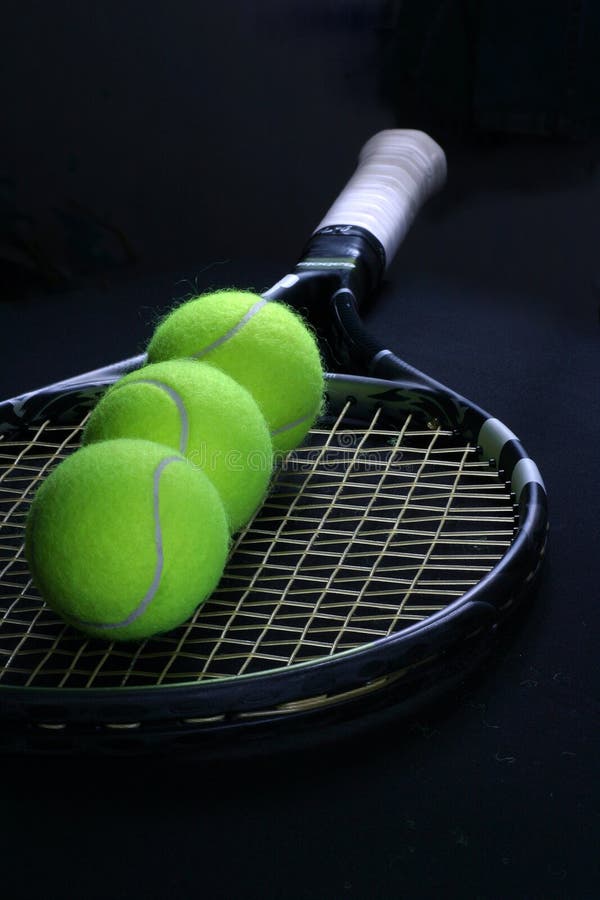 Tennis ball in the racket on the black background