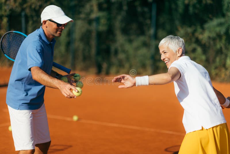 Tennis Instructor with Senior Woman, Tennis Training Lesson Stock Photo