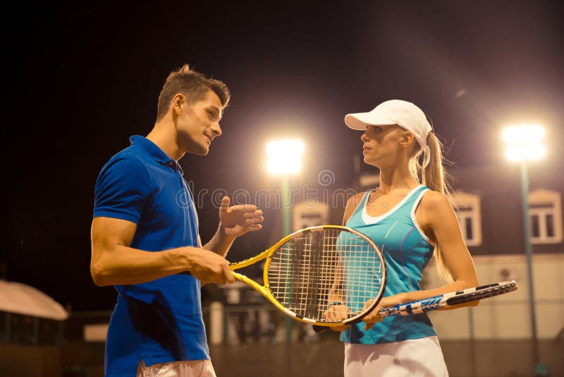 Tennis maschii e femminili che parlano all'aperto fotografie stock Tennis maschii e femminili che parlano all'aperto fotografie stock