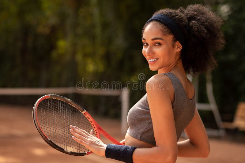 Dark-haired young woman with tennis racket royalty free stock image