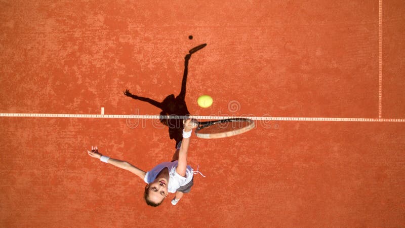 Young female tennis player hitting yellow ball on tennis terrain. Young female tennis player hitting yellow ball on tennis terrain